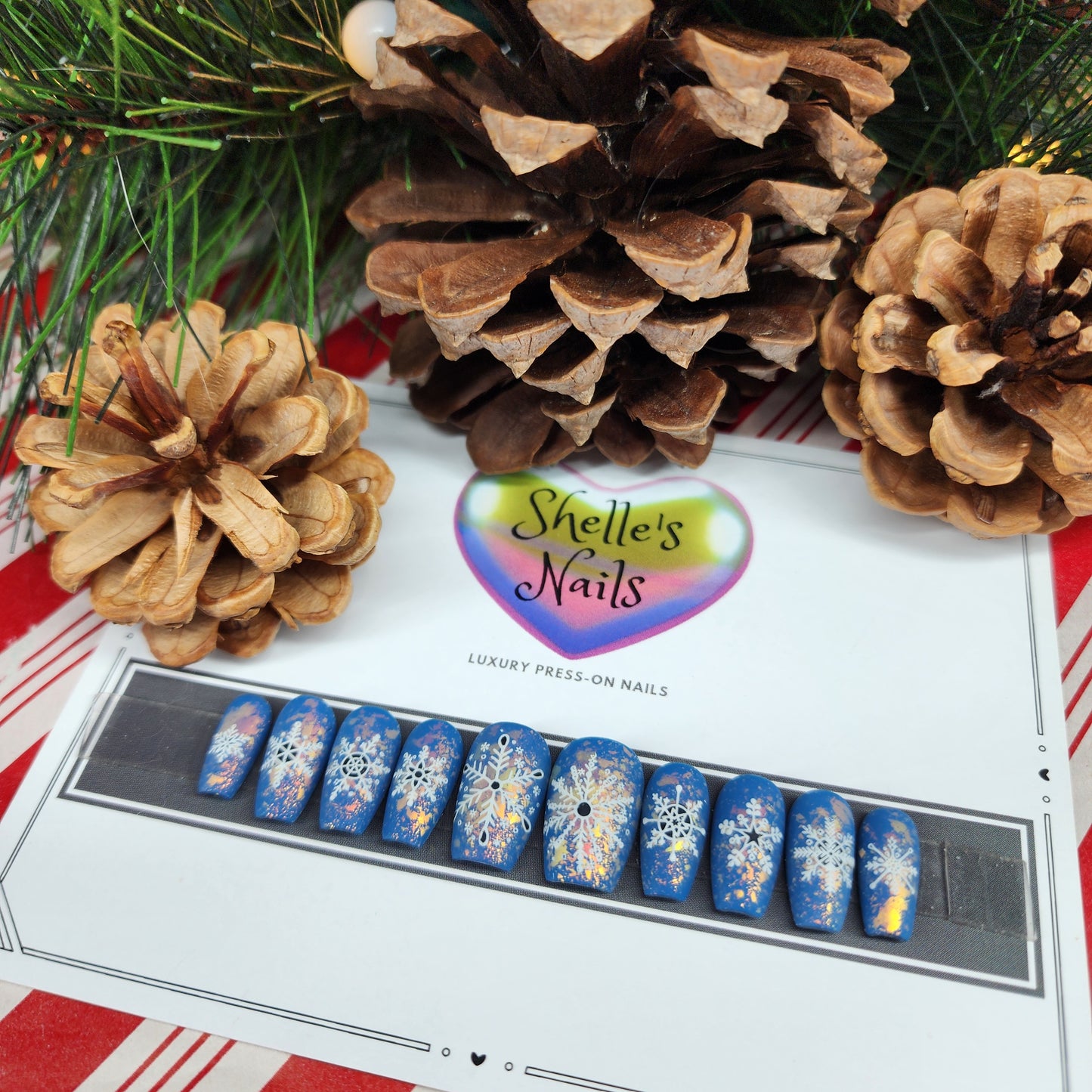 Embrace winter magic with Arctic Glimmer Reusable Gel Extensions. Featuring intricate snowflakes on a cool blue base with shimmering flakes, these sparkling press-on nails are perfect for festive and seasonal styles. Durable, reusable, and easy to apply, they bring frosty elegance to your fingertips.