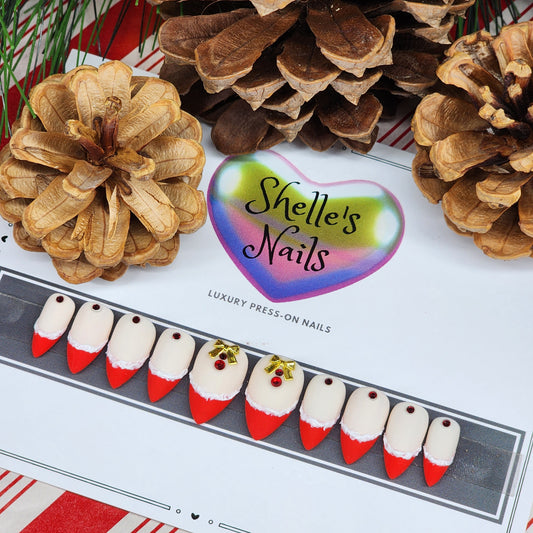 Shop our Holiday French Press-On Nails with red French tips, textured white edges, ruby gems, and gold bows. Reusable gel extensions for a festive, elegant look this season.