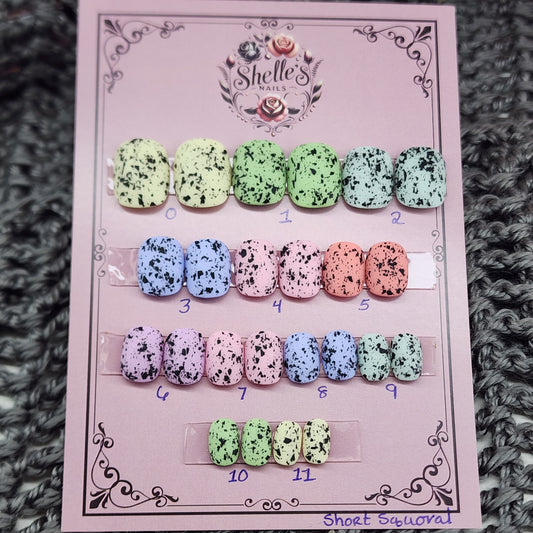 Ready to Wear set of nails in short squoval, pastel in color with black flecks resembling eggs found in nature. 