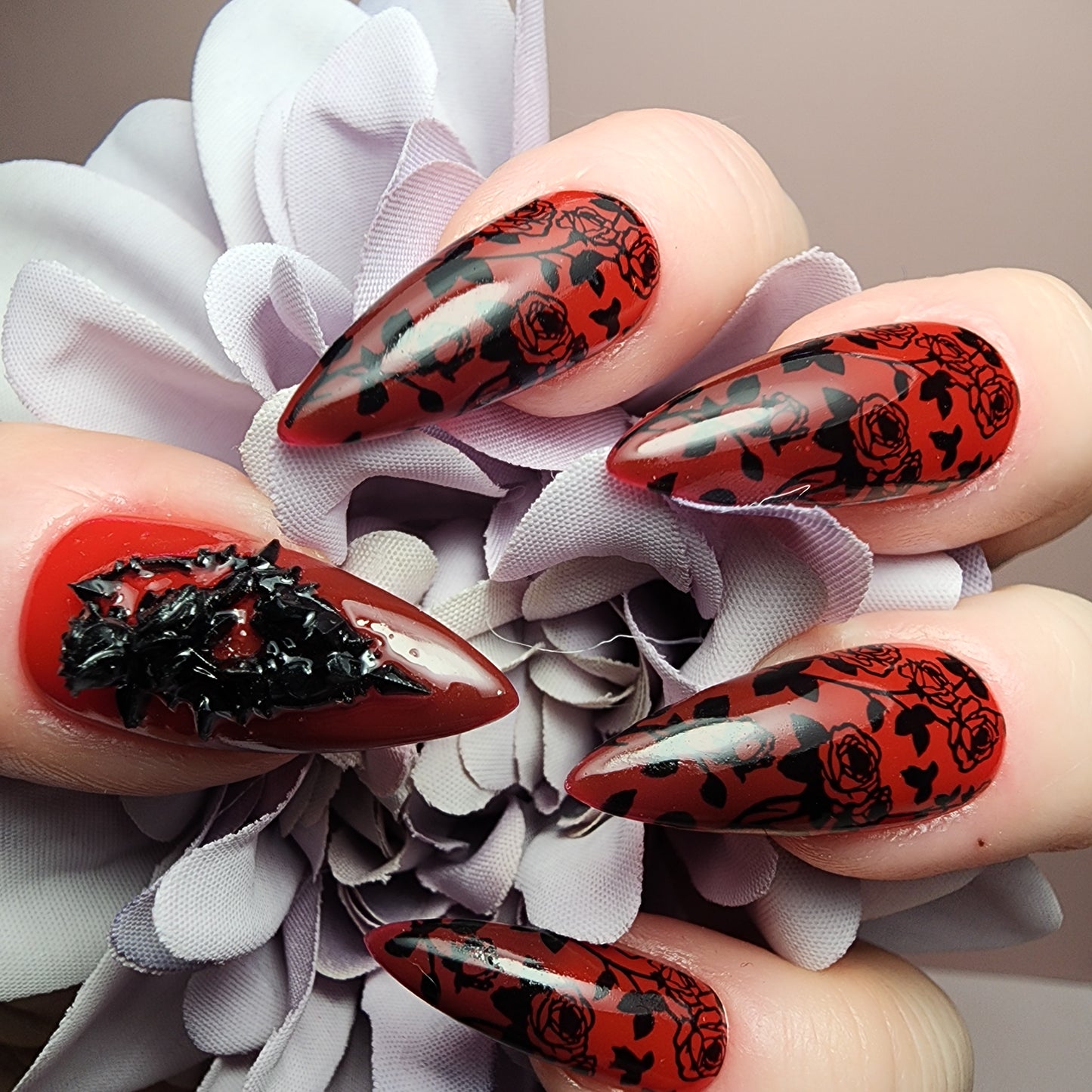 Dark romantic press on nails with heat-changing gel polish that shifts from deep red to crimson red, finished with gothic black rose art.