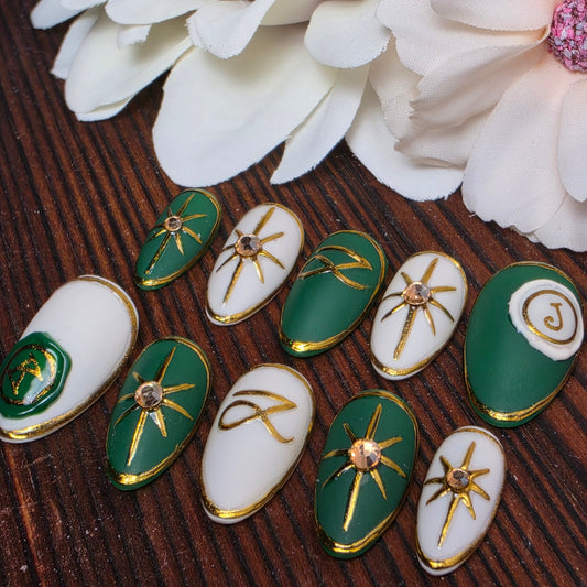 Luxury press-on nails inspired by Jung Kook’s GOLDEN album featuring jewel tone emerald or royal blue polish with sculpted gold star accents. Handmade and made to order.