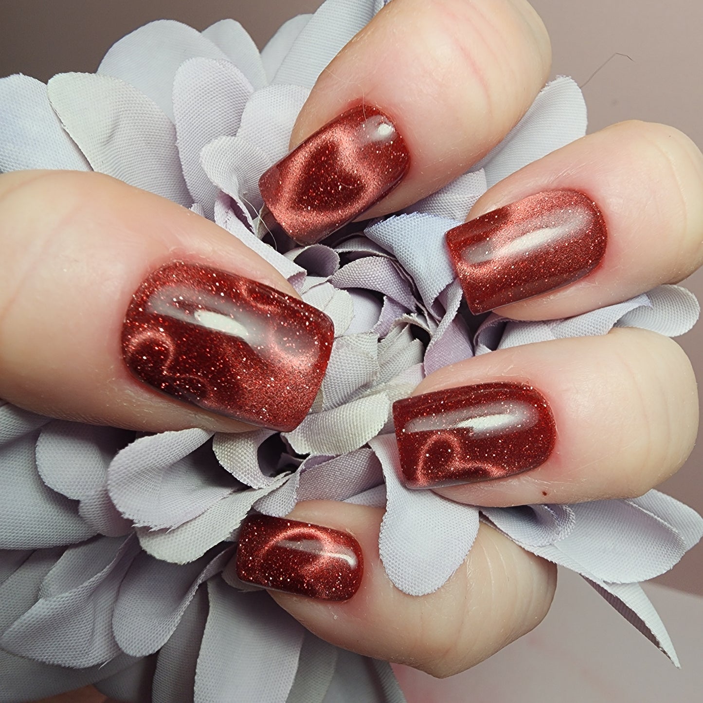 Deep crimson red cat-eye heart press-on nails with glossy magnetic velvet finish, handmade by Shelle’s Nails