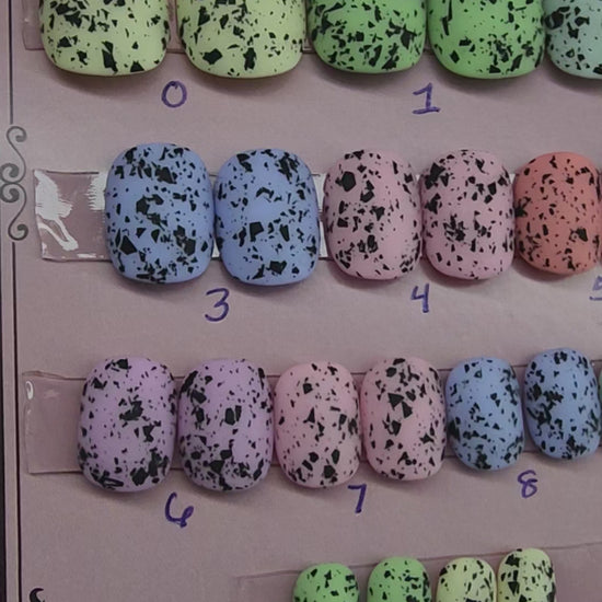 Ready to Wear set of nails in short squoval, pastel in color with black flecks resembling eggs found in nature. 